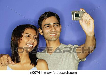 Couple taking a picture of themselves, smiling View Large Photo Image Stock Image - Couple taking a picture of themselves, smiling. Fotosearch