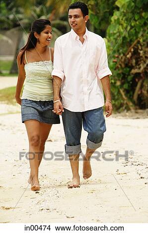 Couple walking along beach, holding hands View Large Photo Image Picture - Couple walking along beach, holding hands. Fotosearch