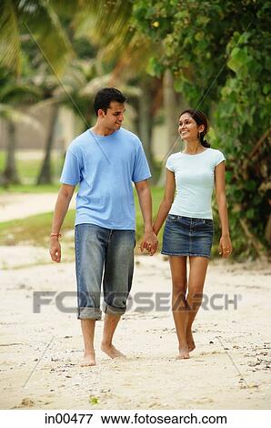 Couple walking along beach, holding hands View Large Photo Image Stock Photo - Couple walking along beach, holding hands. Fotosearch