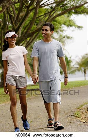 Picture - Couple walking hand in hand, smiling. Fotosearch