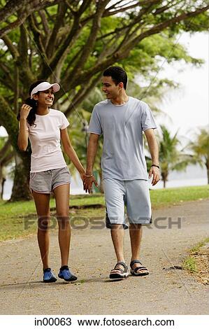 Couple walking hand in hand View Large Photo Image Stock Image - Couple walking hand in hand. Fotosearch
