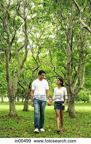 Couple walking in park, holding hands View Large Photo Image Stock Photo - Couple walking in park, holding hands. Fotosearch