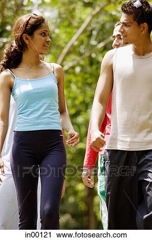 Couple walking, people behind them View Large Photo Image Stock Image - Couple walking, people behind them. Fotosearch
