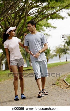 Couple walking side by side, talking View Large Photo Image Stock Photograph - Couple walking side by side, talking. Fotosearch
