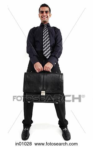Executive carrying briefcase looking at camera View Large Photo Image Stock Photo - Executive carrying briefcase looking at camera. Fotosearch
