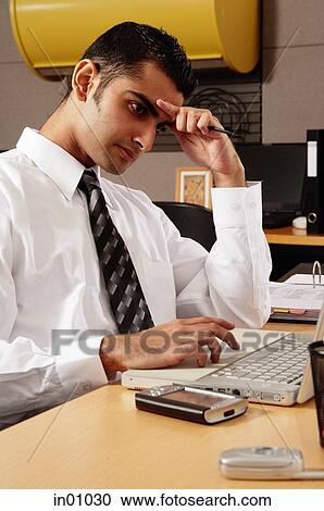 Executive sitting at desk, hand on head View Large Photo Image Stock Image - Executive sitting at desk, hand on head. Fotosearch
