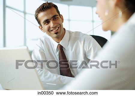 Executive smiling at another person View Large Photo Image Stock Image - Executive smiling at another person. Fotosearch
