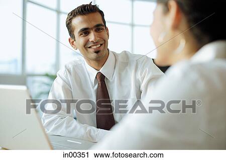 Stock Image - Executive smiling at person in front of him. Fotosearch