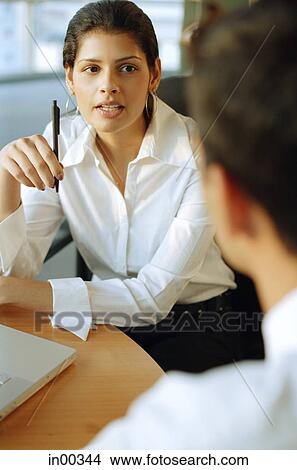 Picture - Executives discussing, over the shoulder view. Fotosearch