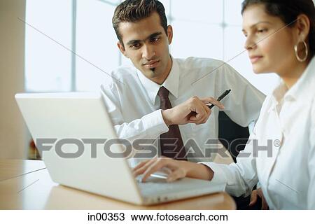 Executives working together, looking at laptop View Large Photo Image Stock Image - Executives working together, looking at laptop. Fotosearch
