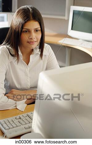 Female executive at desk, facing computer, arms crossed View Large Photo Image Stock Photograph - Female executive at desk, facing computer, arms crossed. Fotosearch