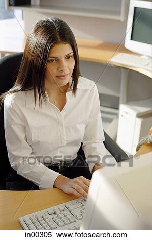 Female executive at desk, facing computer View Large Photo Image Stock Photography - Female executive at desk, facing computer. Fotosearch