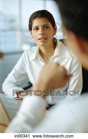 Stock Image - Female executive facing man, over the shoulder view. Fotosearch