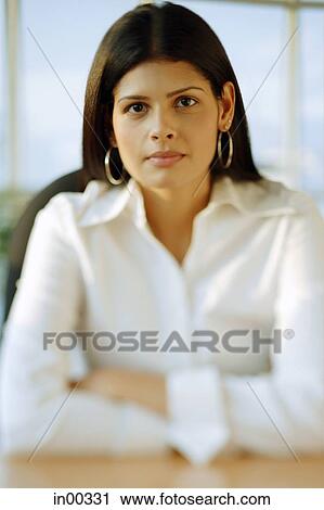 Stock Image - Female executive, looking at camera, portrait. Fotosearch