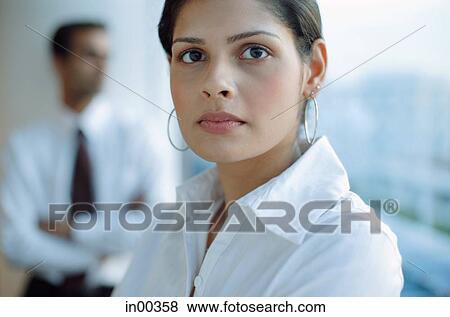 Female executive looking at camera, people in the background View Large Photo Image Stock Photo - Female executive looking at camera, people in the background. Fotosearch