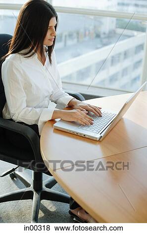 Female executive using laptop, high angle view View Large Photo Image Stock Photo - Female executive using laptop, high angle view. Fotosearch