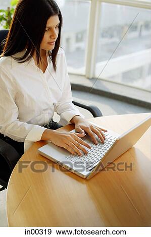Stock Photo - Female executive using laptop, portrait. Fotosearch