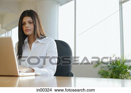 Picture - Female executive working on laptop, portrait. Fotosearch