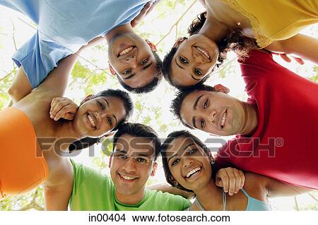 Group of young adults arms around each other, smiling View Large Photo Image Picture - Group of young adults arms around each other, smiling. Fotosearch