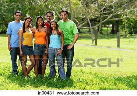 Group of young adults standing in park View Large Photo Image Stock Image - Group of young adults standing in park. Fotosearch