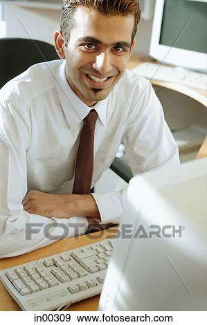 Male executive at desk, arms crossed, looking at camera View Large Photo Image Stock Photo - Male executive at desk, arms crossed, looking at camera. Fotosearch