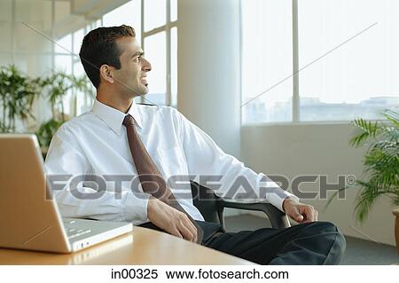 Male executive turning away from desk, looking at window View Large Photo Image Stock Photography - Male executive turning away from desk, looking at window. Fotosearch