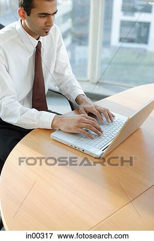 Male executive using laptop, high angle view View Large Photo Image Stock Photo - Male executive using laptop, high angle view. Fotosearch