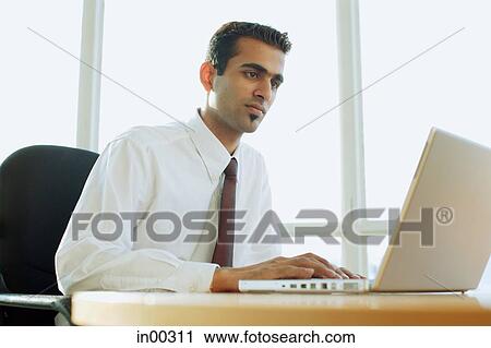 Stock Image - Male executive using laptop. Fotosearch