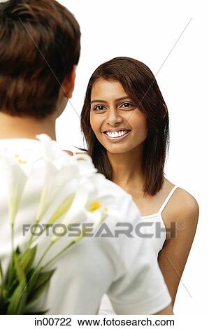 Man holding flowers behind his back, facing woman View Large Photo Image Stock Image - Man holding flowers behind his back, facing woman. Fotosearch