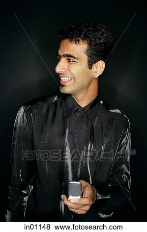 Man holding mobile phone, smiling View Large Photo Image Stock Photo - Man holding mobile phone, smiling. Fotosearch
