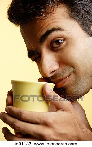 Man holding mug close to face, winking View Large Photo Image Stock Photo - Man holding mug close to face, winking. Fotosearch