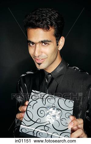 Man holding present, looking at camera View Large Photo Image Stock Image - Man holding present, looking at camera. Fotosearch