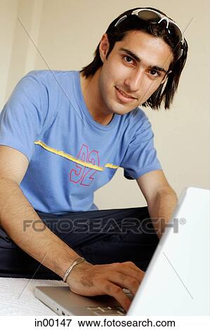 Man in front of laptop, looking at camera View Large Photo Image Stock Photo - Man in front of laptop, looking at camera. Fotosearch