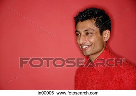 Stock Photograph - Man in red shirt against red background, looking away. Fotosearch