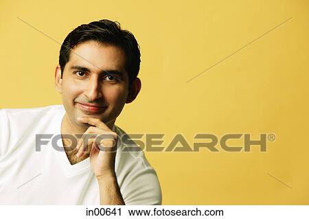 Man looking at camera, hand on chin, smiling View Large Photo Image Stock Image - Man looking at camera, hand on chin, smiling. Fotosearch