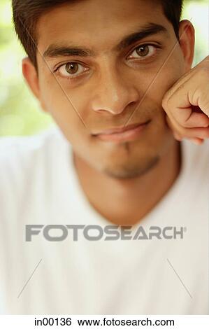 Man looking at camera, hand on face View Large Photo Image Stock Photograph - Man looking at camera, hand on face. Fotosearch