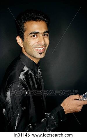 Man looking at camera, holding mobile phone View Large Photo Image Stock Photography - Man looking at camera, holding mobile phone. Fotosearch