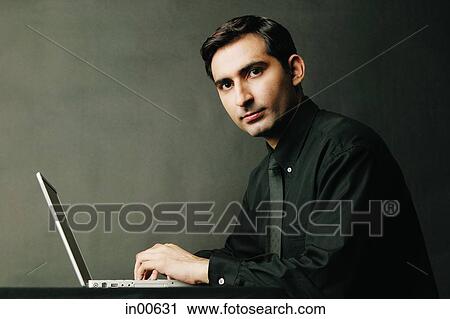 Man looking at camera, laptop open in front of him, portrait View Large Photo Image Stock Image - Man looking at camera, laptop open in front of him, portrait. Fotosearch