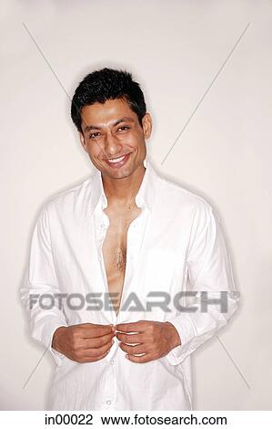 Stock Image - Man looking at camera, shirt partially unbuttoned. Fotosearch