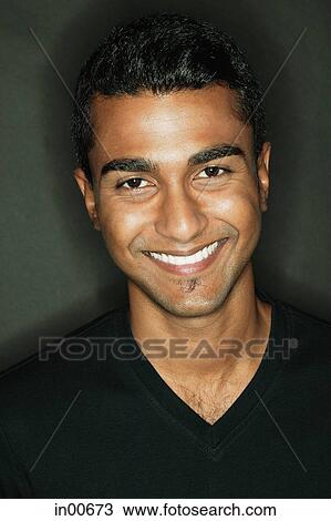 Stock Image - Man looking at camera, smiling. Fotosearch