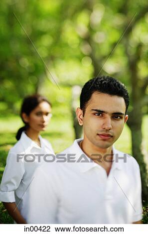 Man looking at camera, woman in the background View Large Photo Image Stock Image - Man looking at camera, woman in the background. Fotosearch