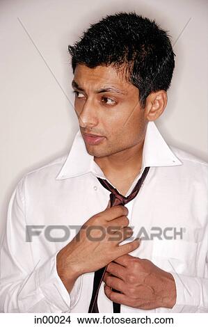 Man looking away, fixing tie View Large Photo Image Picture - Man looking away, fixing tie. Fotosearch