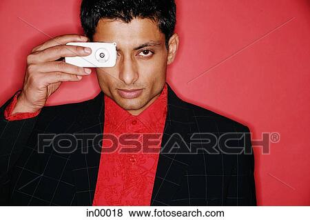 Stock Photo - Man looking through camera phone. Fotosearch
