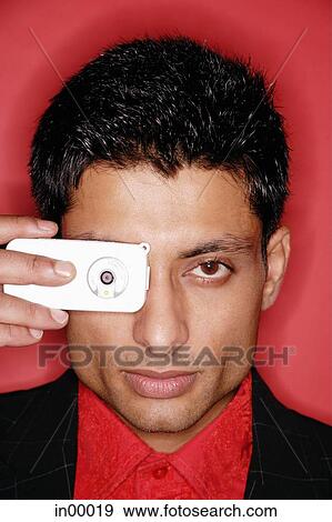 Man looking through camera phone, headshot View Large Photo Image Stock Photo - Man looking through camera phone, headshot. Fotosearch