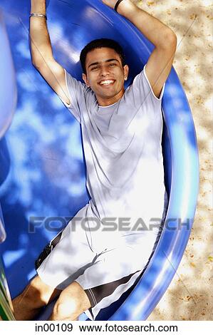 Man sliding on slide, looking up at camera View Large Photo Image Stock Photo - Man sliding on slide, looking up at camera. Fotosearch