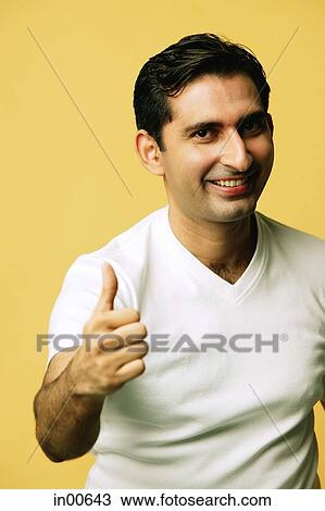 Man smiling at camera, making "thumbs up" sign View Large Photo Image Stock Image - Man smiling at camera, making "thumbs up" sign. Fotosearch