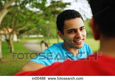 Man smiling, facing another person, over the shoulder view View Large Photo Image Stock Photo - Man smiling, facing another person, over the shoulder view. Fotosearch