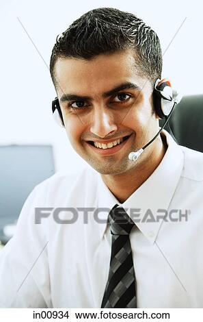 Picture - Man using headset, smiling at camera. Fotosearch