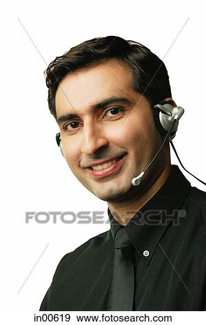 Stock Photo - Man using headset, smiling, looking at camera. Fotosearch