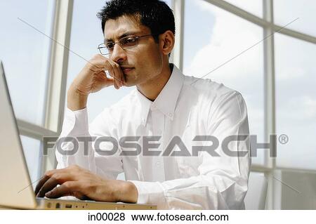 Man using laptop, hand on chin, portrait View Large Photo Image Stock Photo - Man using laptop, hand on chin, portrait. Fotosearch
